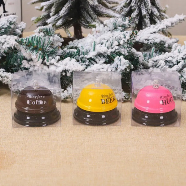 Three clear plastic packages containing metal service bells for coffee, beer, and hug.