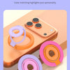 Multiple colored MagSafe phone ring holder stands displayed on a peach-colored smartphone.