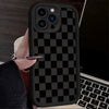 A black and white checkered silicone phone case is shown on a smartphone, held by a hand.