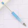 A blue and white DIY beadable pen is shown lying on a white surface.