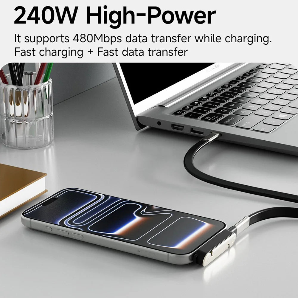A silver phone is resting on a black adapter and stand next to a laptop.