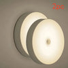 A set of two round LED night lights with a motion sensor, shown against a neutral background.
