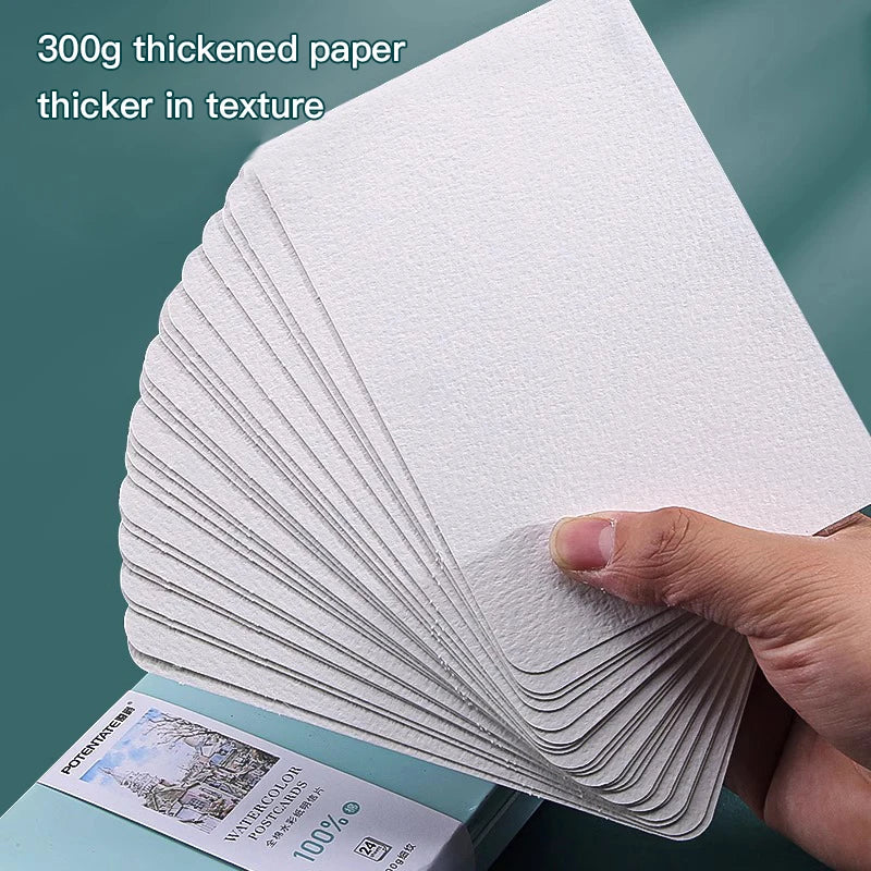 A stack of 300g thickened paper watercolor postcards is shown being held by a hand.