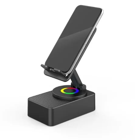 A black wireless speaker with an adjustable phone stand and a colored night light base.