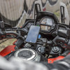 A close-up view of a motorcycle dashboard showing a mounted smartphone and an instrument cluster.
