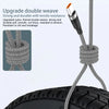 A close-up of a braided nylon charging cable with an orange connector being tied around a tire.