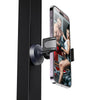 A black magnetic phone holder is attached to a black door, displaying a fitness model on the phone screen.