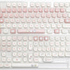 A close-up view of a white mechanical keyboard featuring pink and light gray dye-sublimated PBT keycaps.