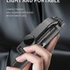 A hand holds a compact mini Bluetooth selfie stick with an LED light and tripod stand against a dark background.