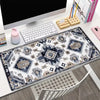 A vintage Persian rug gaming mouse pad with a non-slip rubber base is displayed on a desk.