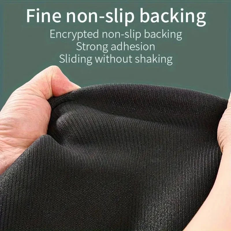 Close-up of a black non-slip backing fabric being held by a hand.