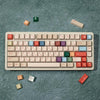 A set of retro AI illustrator PBT keycaps in cherry profile with dye-sublimation, scattered on a teal surface.