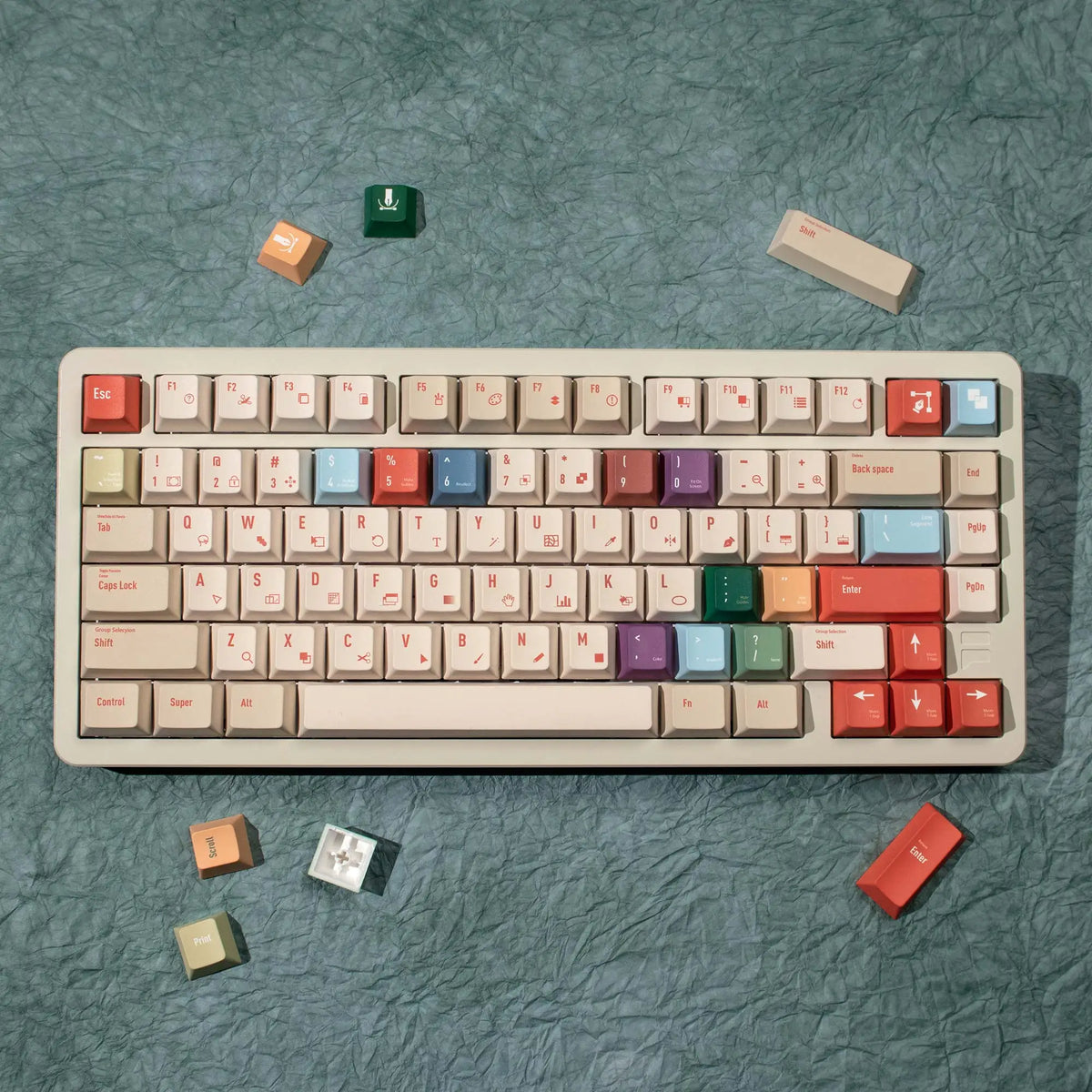 A set of retro AI illustrator PBT keycaps in cherry profile with dye-sublimation, scattered on a teal surface.