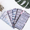 A stack of A6 budget planner sheets with envelope pockets and expense sheets in various pastel colors