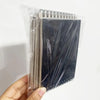 A clear plastic package containing a set of sketchbooks with dark covers and light-colored paper inside.