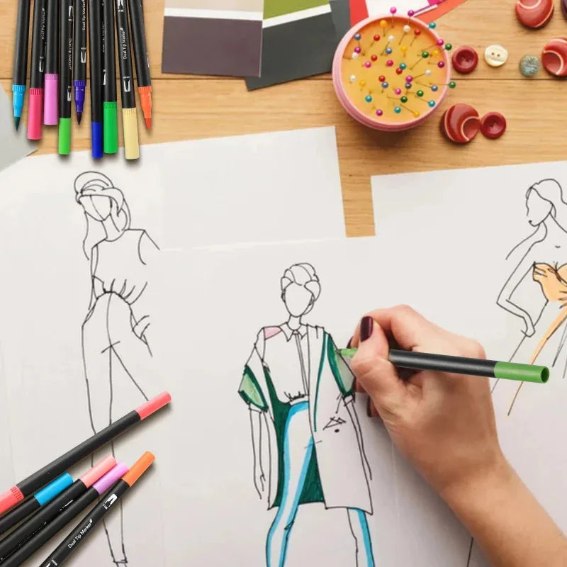 A hand draws a figure with a dual-tip brush marker on white paper next to a set of vibrant markers and color palettes.