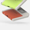 A silver M.2 NVMe SSD enclosure is shown with a lime green adapter, positioned on a white surface.