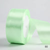 A roll of light green satin ribbon used for gift wrapping and DIY crafts.
