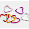 A set of five colorful heart-shaped spring clasps and carabiner keychains in various shades of pink, purple, and gold.