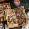 An open vintage book with detailed illustrations and text lies on a wooden surface next to a candle and eyeglasses.