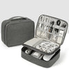 A gray travel cable organizer bag with an open compartment showing various electronic cables and accessories.