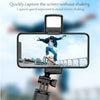 A selfie stick tripod with a fill light and wireless remote is positioned to capture a clear image of a person jumping agains
