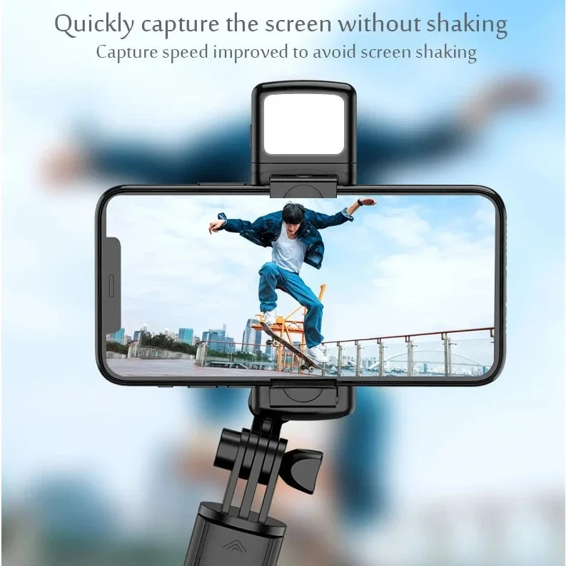 A selfie stick tripod with a fill light and wireless remote is positioned to capture a clear image of a person jumping agains