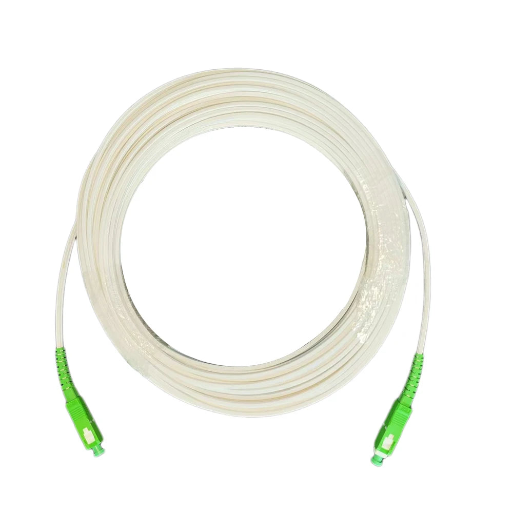 A coil of white single-mode fiber optic cable with green connectors.