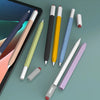 Une collection de stylos de différentes couleurs et un stylet blanc sont présentés sur une surface vert clair à côté d'un écr