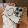A hand holds a clear phone case decorated with glitter diamonds and multiple lenses.