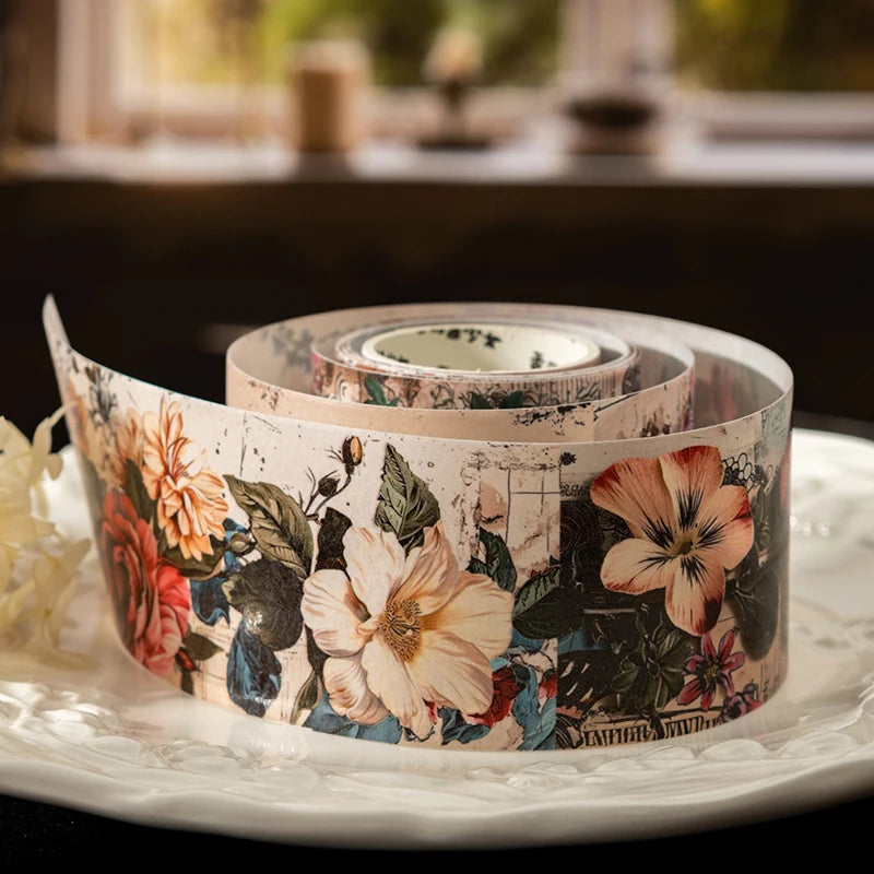 Roll of decorative floral patterned washi tape on a white plate
