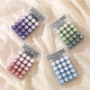 A collection of small plastic containers filled with colorful pills or beads arranged in a gradient pattern.