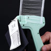 A hand holds a light green professional apparel tagging gun kit with a black tag.