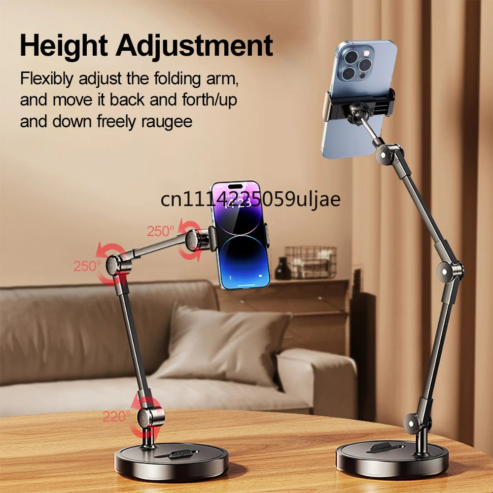 A black multi-angle adjustable phone holder stand with a silver phone mounted on an arm, shown in a home setting.