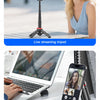 A woman smiling while using a live streaming tripod and a phone stand for video recording.