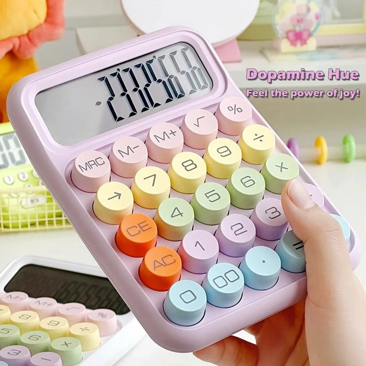 A hand holds a pink 12-digit desktop calculator with mechanical keys and various colored buttons.