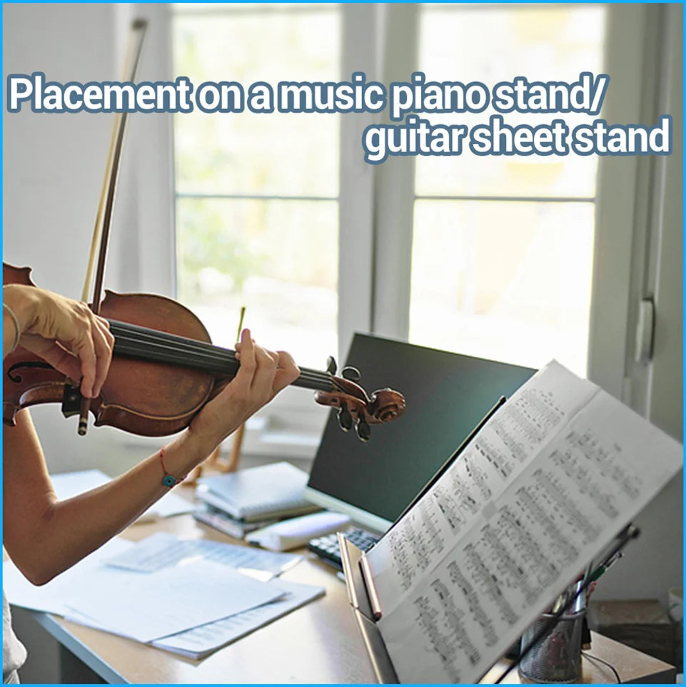 Hands playing a violin on a music piano stand or guitar sheet stand with sheet music visible.