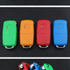 A set of realistic fake car keys in various colors, including green, orange, red, and blue, displayed on a black background.
