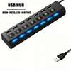 Schwarzer USB-Hub mit sieben Anschlüssen und blauer LED-Beleuchtung, von oben.