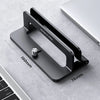 A black vertical laptop stand designed by Ugreen shown on a gray surface next to a laptop keyboard.