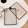 A silver iPad Pro is shown alongside its black polka dot protective case on a white surface.