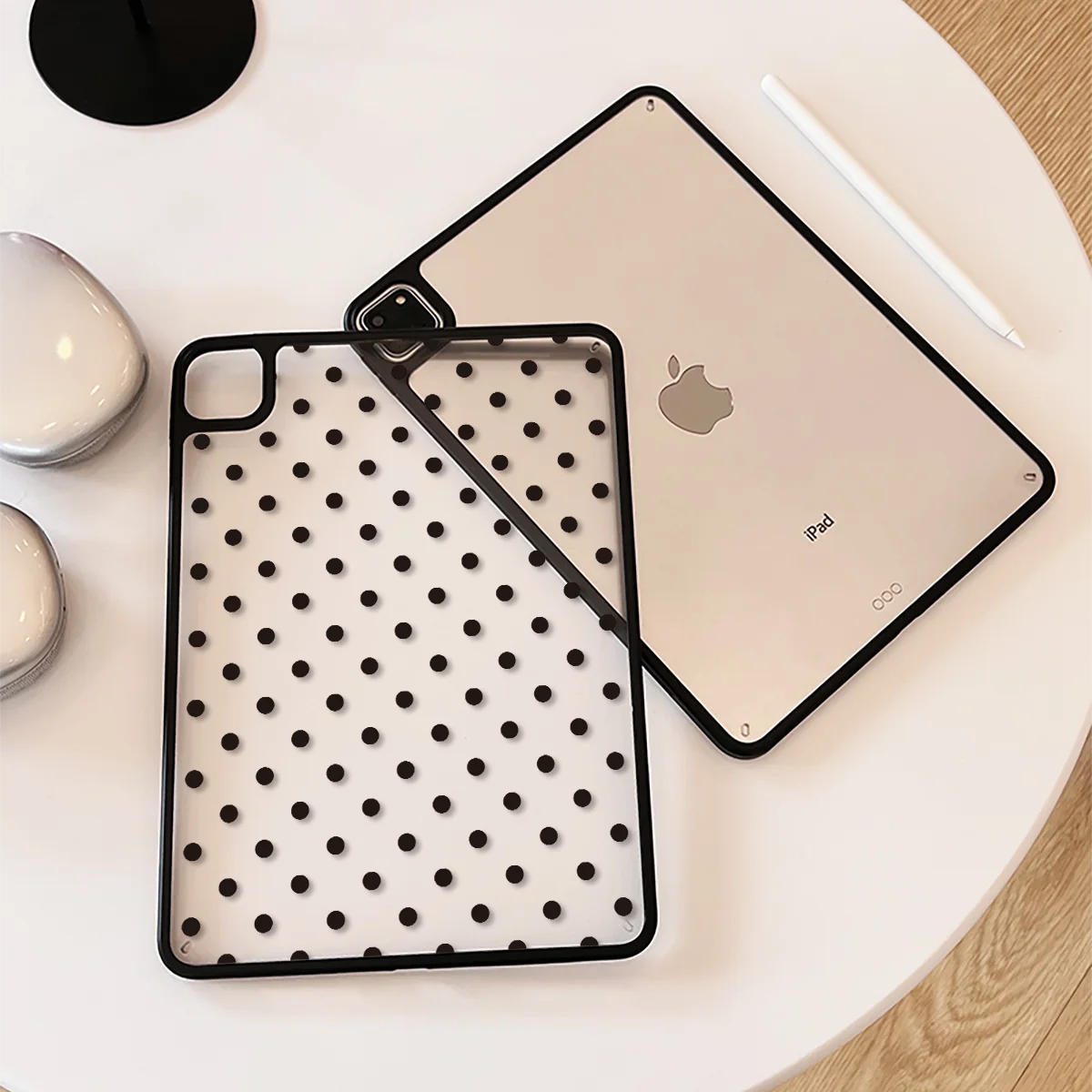 A silver iPad Pro is shown alongside its black polka dot protective case on a white surface.