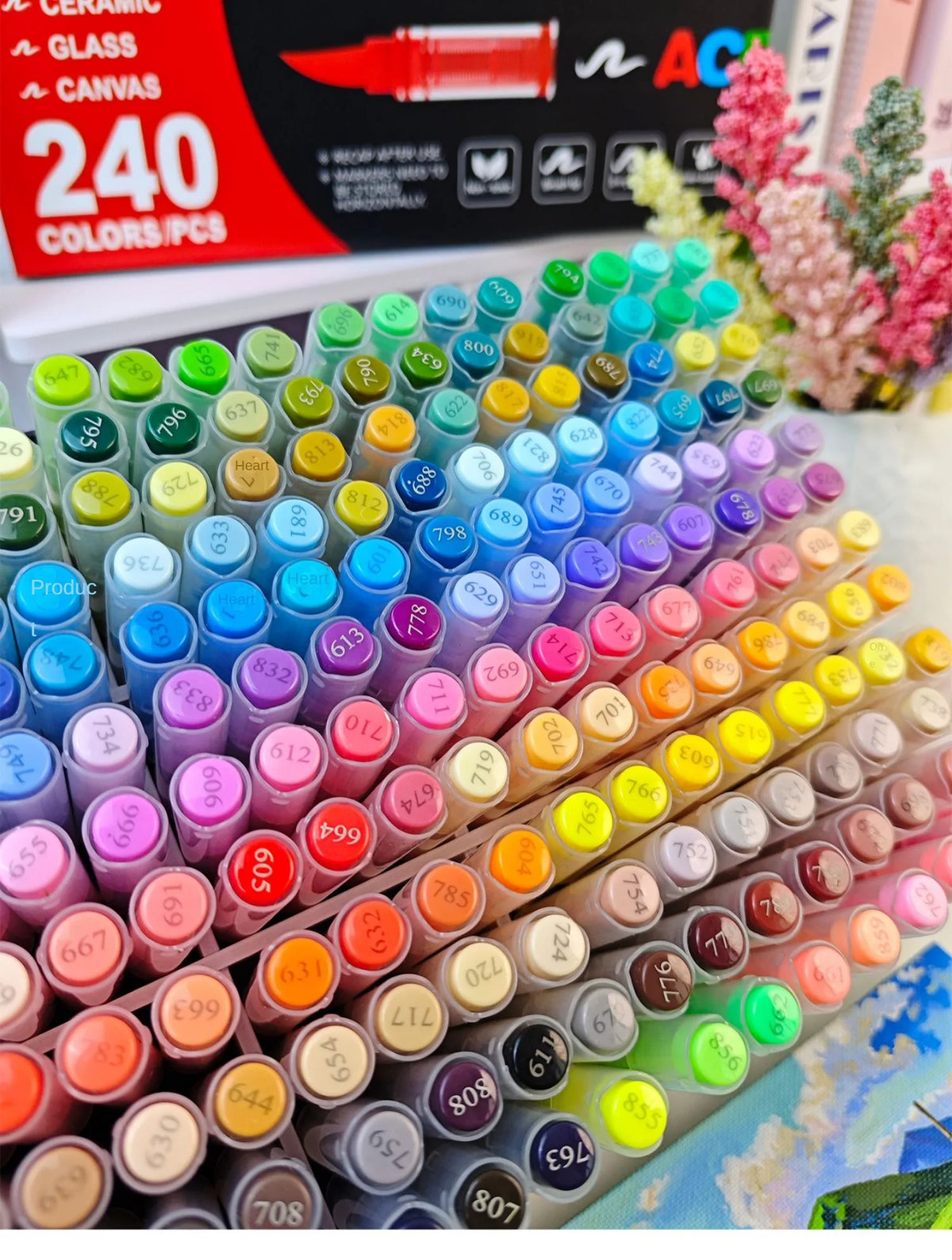 A large collection of vibrant acrylic art markers in various colors arranged in rows.