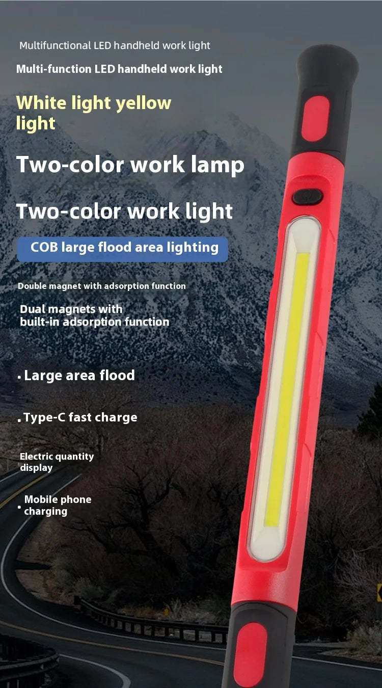 A red and black LED handheld work light with a yellow light, shown outdoors.