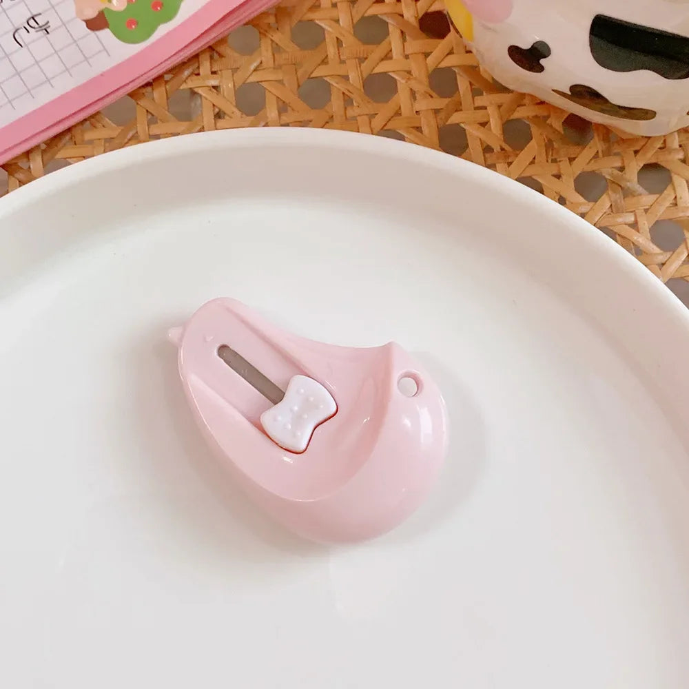 A pink cat paw mini cutter is placed on a white plate, showing its shape and function for crafts.