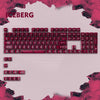 A close-up view of a mechanical keyboard with red keycaps and a pink background, featuring the word ICEBERG.