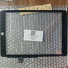 A black iPad screen is displayed on a clear plastic surface with a QR code sticker placed in the center.