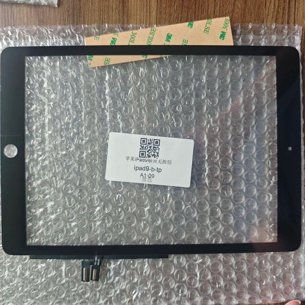 A black iPad screen is displayed on a clear plastic surface with a QR code sticker placed in the center.
