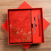 A red luxury PU leather notebook set with a gold embossed landscape design and a silver pen inside a square box.