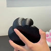 A hand is holding a black 3D printed cat paw phone stand with an anti-slip base.